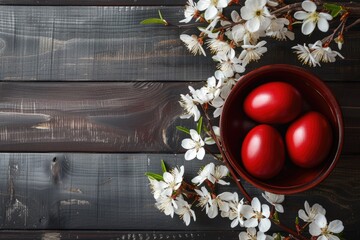 Easter dark red eggs and spring white flowers on dark wooden table.