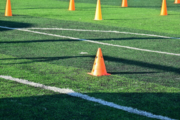 artificial green grass soccer field with orange training cones