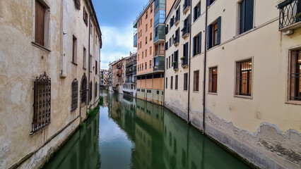 Fototapeta na wymiar The picturesque water channel of San Massimo beautifully winds through the heart of the historic city of Padua, Italy, gracefully passing by charming residential houses. City in Veneto, Northern Italy