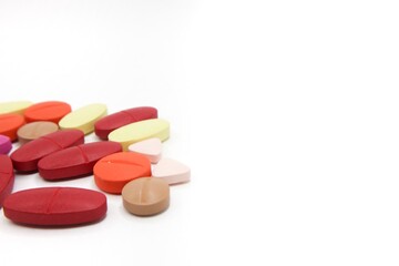 Detailed photos of oval, round and triangular shaped tablets in various colors: red, orange, yellow and cream. The photo was taken on a white background