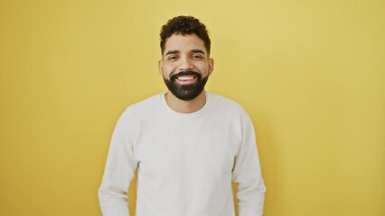 Cheerful young man, standing confidently, sends love with a flying kiss to the camera. over a vibrant, isolated yellow background, his expression - a mix of sexy, lovely, and fun.