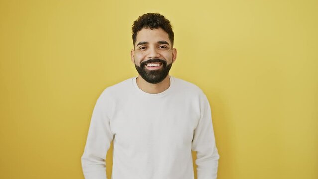 Cheerful young man, standing confidently, sends love with a flying kiss to the camera. over a vibrant, isolated yellow background, his expression - a mix of sexy, lovely, and fun.