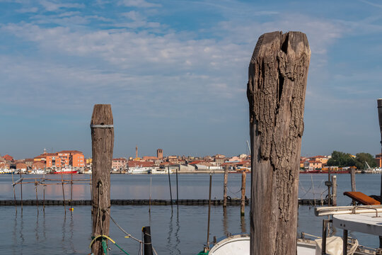 Wooden briccola in Sottomarina, Veneto, Northern Italy, Europe. Panoramic view on idyllic harbor of tourist town Chioggia. Tranquil seascape in Venetian Lagoon. Mediterranean Adriatic Sea in summer