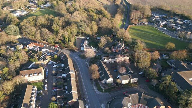 Bury st edmunds in england, showing residential area with roads and trees, golden hour, aerial view