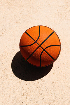 Used basketball ball on concrete surface of outdoor court