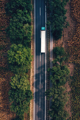 Trucking and freight transport logistic concept, aerial shot of semi-truck on highway from drone pov