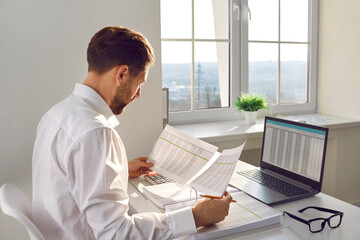 Financial accountant, auditor or business man doing paperwork in the office. Young corporate...