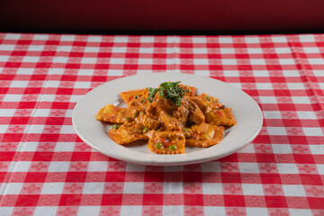 Ravioli pastore on a plate with a tablecloth in the background