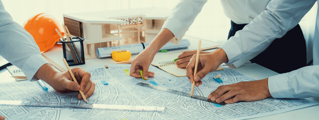 Worker, architect and engineer work on real estate construction project oratory planning with...