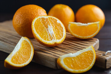 Sliced oranges fruit on wooden board. Orange juicy fruit, citrus minimal concept. Close-up