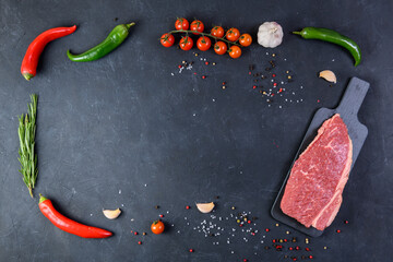 Raw fresh marbled meat and seasonings on dark background top view