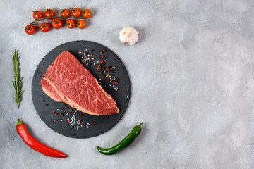 Raw fresh marbled meat and seasonings on grey background top view