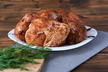 Raw chicken in spices, close-up. Chicken for baking.