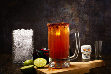 Michelada, typical mexican cocktail on a wooden table. Cocktail based on beer.