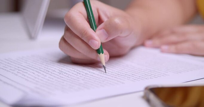 Close-up of an individual doing some editing and proofreading of an essay written in the Thai language.