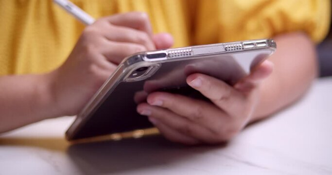 Browsing the internet while writing some notes at the same time using a digital and electronic tablet.