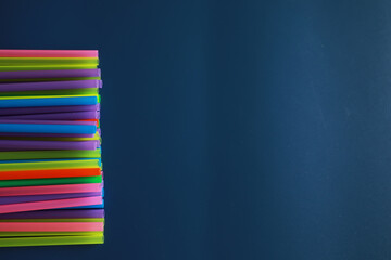 Colorful plastic drinking straws, close up as background. colored tubules for juice and cocktails on black wooden table