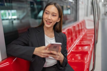 Young Asian Businesswoman Using Phone On The Public Skytrain