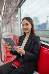 Young asian business woman with digital tablet in the skytrain