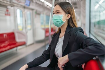 Asian businesswoman wearing mask in a skytrain