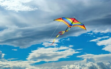 rainbow kite flying in blue sky with clouds in summer with copyspace - obrazy, fototapety, plakaty