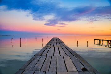Scenic view of a wooden pier over a lake at sunset