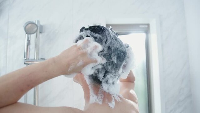 お風呂で髪を洗う40代男性
