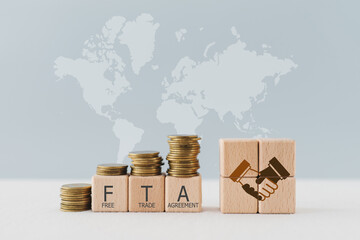 wooden cube blocks with the word FTA, abbreviation for Free Trade Agreement and handshake icon ...