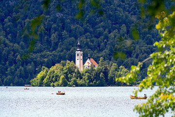 Lake Bled with church on an island and woodland in the background on a cloudy summer day. Photo...