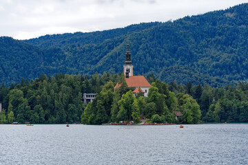 Lake Bled with church on an island and woodland in the background on a cloudy summer day. Photo...