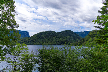 Lake Bled with woodland and mountain panorama in the background on a cloudy summer day. Photo taken August 8th, 2023, Bled, Slovenia.