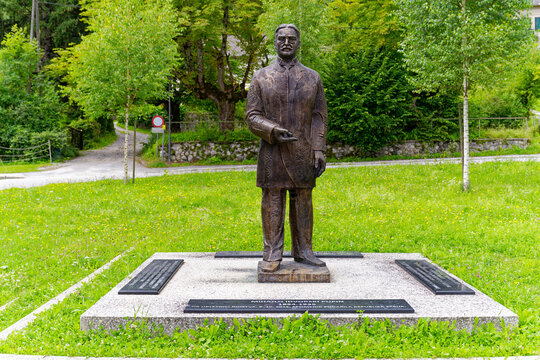 Bronze statue of physicist and writer Mihajlo Idvorski Pupin at lake shore of Lake Bled on a cloudy summer day. Photo taken August 8th, 2023, Bled, Slovenia.