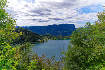Obraz na płótnie Canvas Lake Bled with woodland and mountain panorama in the background on a cloudy summer day. Photo taken August 8th, 2023, Bled, Slovenia.