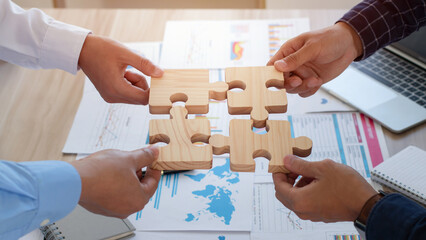 Concept of teamwork, cooperation and partnership. Business people connecting puzzle pieces in office. teamwork, Unity, volunteer, success and strategy.  Business idea by merging jigsaw puzzle. - obrazy, fototapety, plakaty