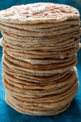 Flatbread lavash, chapati, naan, heap of tortilla on a blue background Homemade flatbread stacked.