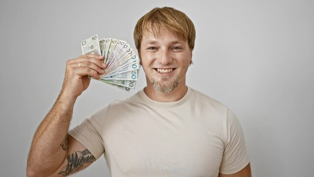 Blond man with beard smiling, holding polish zloty cash against a white background