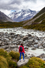 hiker girl walking alongside hooker valley track toward hooker lake and mt cook, famous walk in...