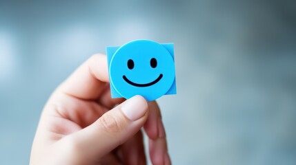 Smiley face icon on a blue cube in the hand