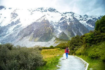 Photo sur Plexiglas Aoraki/Mount Cook hiker girl walking alongside hooker valley track toward hooker lake and mt cook, famous walk in canterbury, new zealand south island