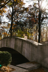 Fototapeta na wymiar Girl runs on stone bridge in forest on fall hike with sunshine