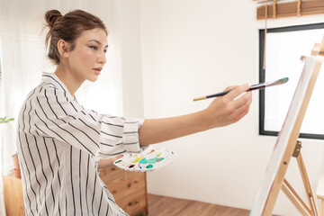 female hobbies about artist and use paintbrush in abstract art for create masterpiece. painter paint with watercolors or oil in studio house. enjoy painting as hobby, recreation, inspiration
