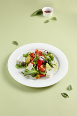 Classic Greek Salad with Feta Cheese and Fresh Vegetables on White Plate