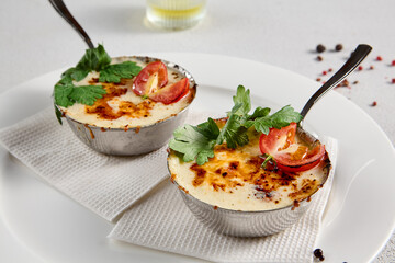 Gourmet julienne with cheese and mushrooms in a white plate, elegantly served with a top view and copy space for menus and culinary guides