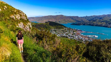 Deurstickers pretty hiker girl enjoying the panorama of lyttelton after finishing the hike on the bridle path from christchurch to lyttelton  beautiful view from gondola summit station, canterbury, new zealand  © Jakub