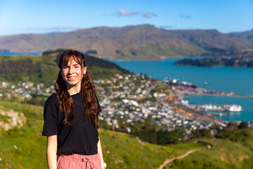 pretty hiker girl enjoying the panorama of lyttelton after finishing the hike on the bridle path...
