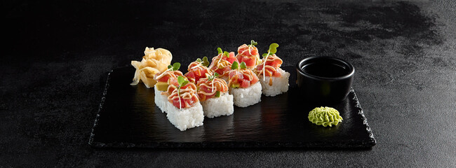 Sushi roll with tuna tartare and avocado on a black slate