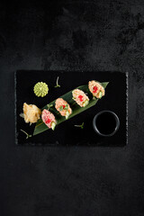 Obraz na płótnie Canvas Elegant spicy sushi assortment with salmon, shrimp, tuna, and eel, top view on dark slate
