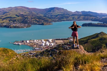 Behangcirkel pretty hiker girl enjoying the panorama of lyttelton after finishing the hike on the bridle path from christchurch to lyttelton  beautiful view from gondola summit station, canterbury, new zealand  © Jakub