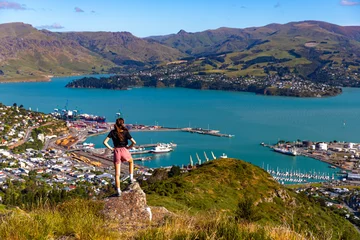 Fotobehang pretty hiker girl enjoying the panorama of lyttelton after finishing the hike on the bridle path from christchurch to lyttelton  beautiful view from gondola summit station, canterbury, new zealand  © Jakub