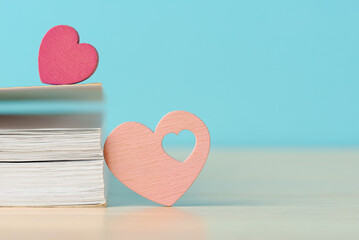 Two wooden hearts with book, symbolizing love and romance